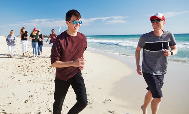 一群留学生沿着海滩散步.