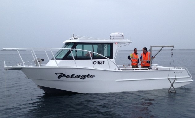 一艘MAFRL研究船在水面上，两名研究人员穿着救生衣.