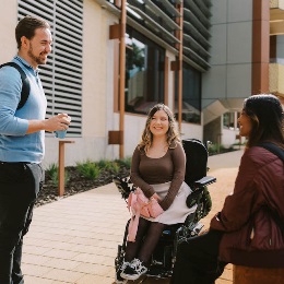 Three students chatting on campus.
