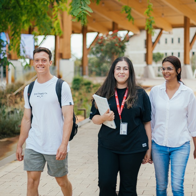 Three Murdoch students walking outside Boola Katitjin smiling
