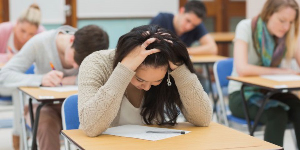 Students taking exam and looking stressed