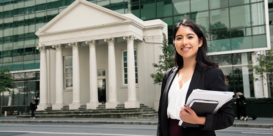 Law student standing in front of law building