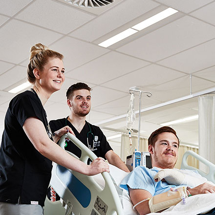 Students with a patient in a bed