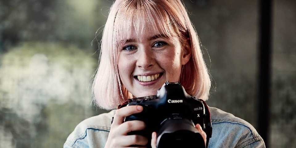 female design student holding camera