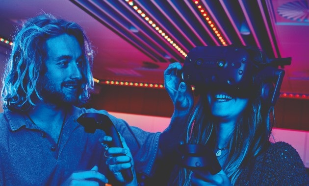 Man helping a women with her VR headset