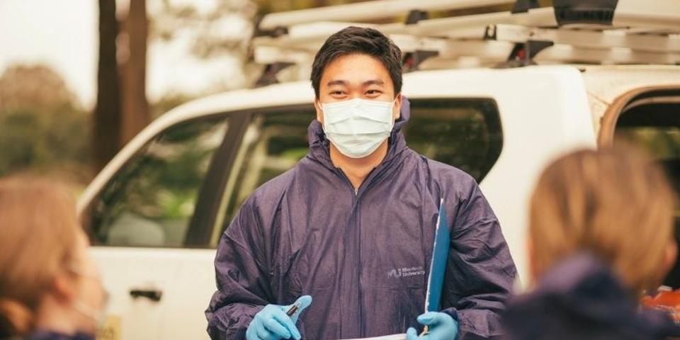 Ian Lim wearing forensic suit, mask and gloves