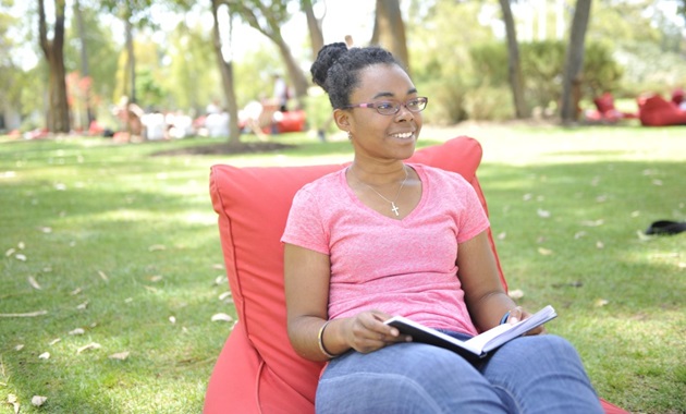 International student Lisa reading a book on Bush Court.