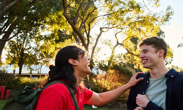 Two students laughing together on Bush Court