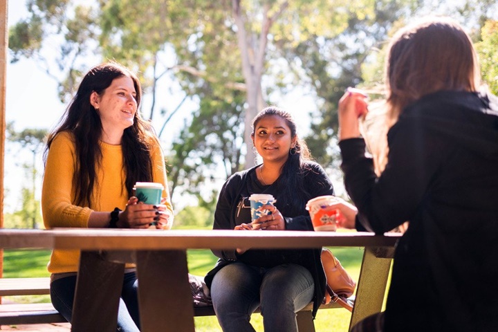 students sitting at picnic table