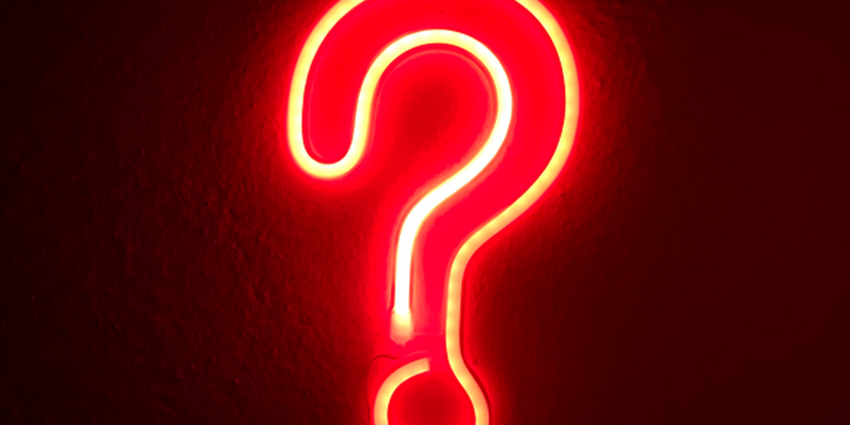 Orange neon sign in the shape of a question mark
