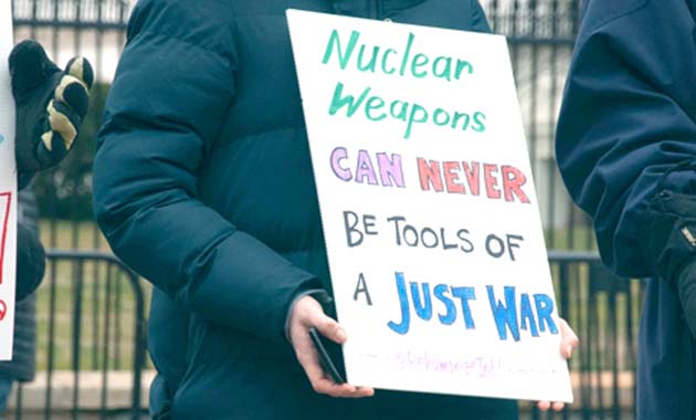 Man holding sign against nuclear weapons