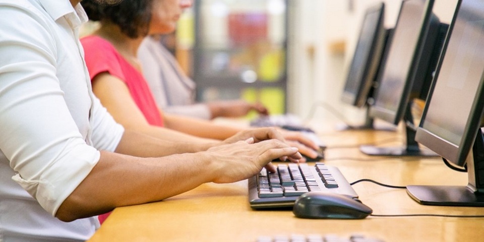 People typing at desktop computers