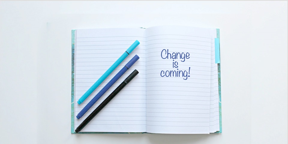 Notepad with writing on it 'Change is coming!'