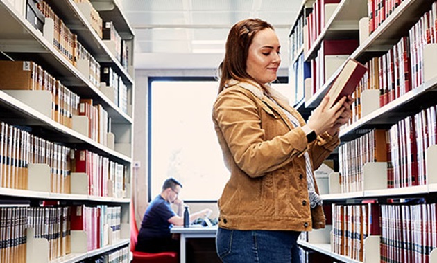 Female student looking at book in the Library
