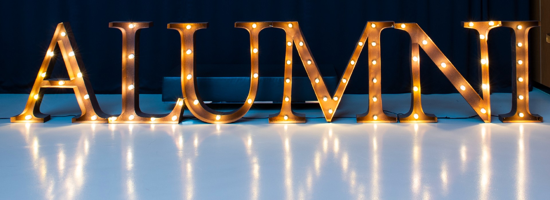 The word ALUMNI written in block letters with lights.