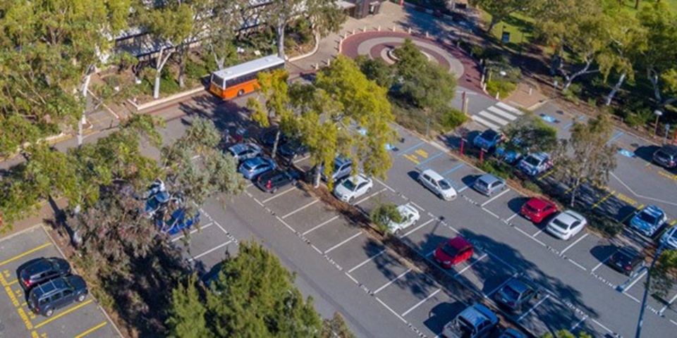 Cars parked in a spacious lot from a bird's eye view.