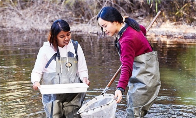 2 people in stream collecting samples