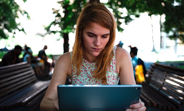 Girl researching on her laptop in a park