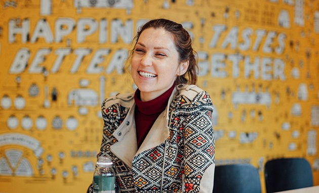 Woman holding a drink while sitting down