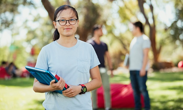 Girl holding folder smiling at camera