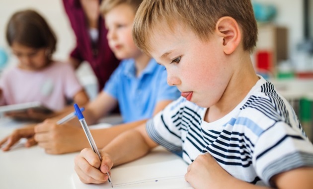 Young primary school boy handwriting