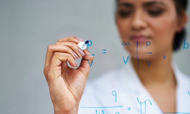 Woman writes equations on glass.