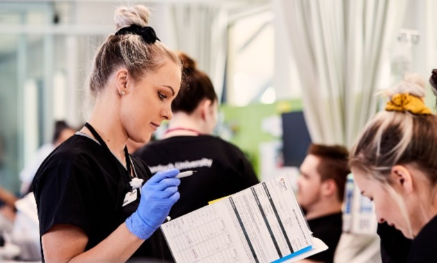 Female nursing looking at patients file