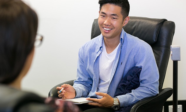 Male student in a therapy session, smiling.