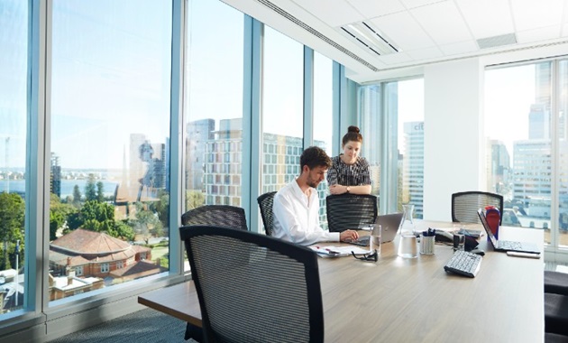 Two people working in a office building overlooking the city