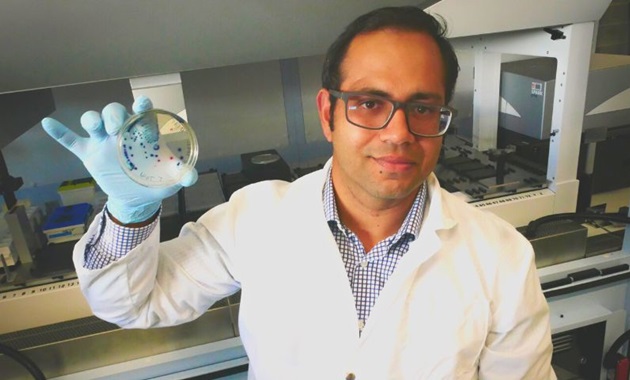 Sam  Abraham holding petri dish in a lab