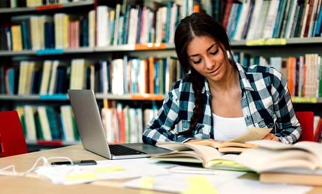 Student studying in the library on her laptop