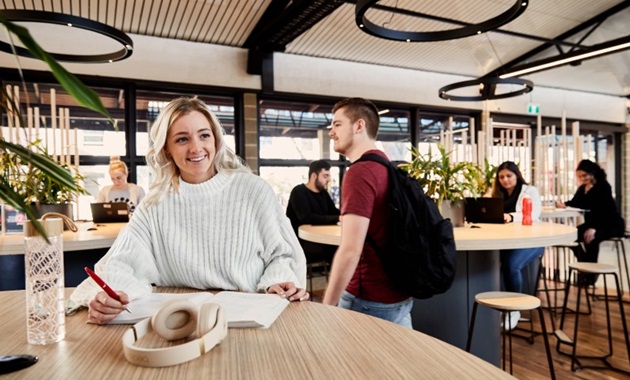 Smiling student studying in the student hub