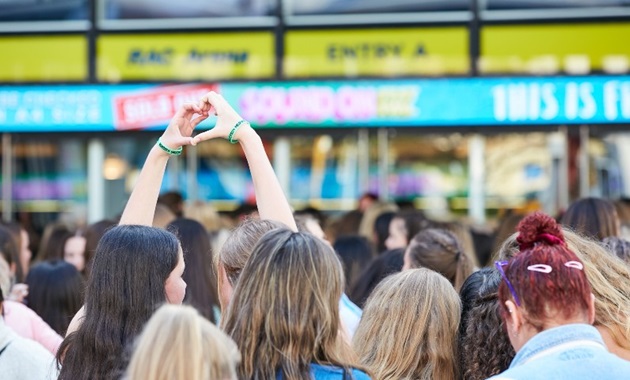 two girls at sound on festival in the crowd lining up