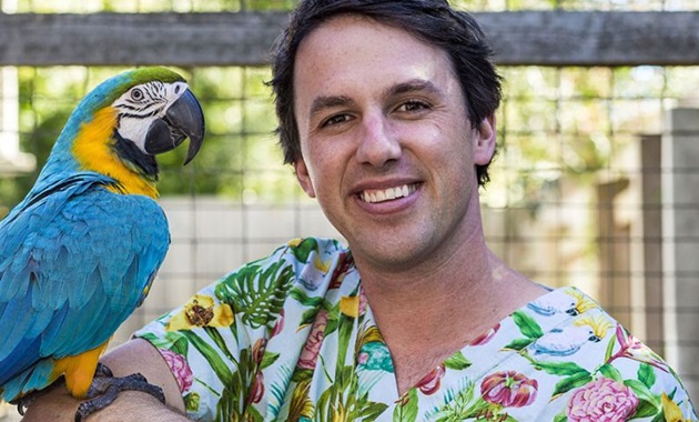 Veterinary surgeon Dr James Haberfield with a macaw on his shoulder