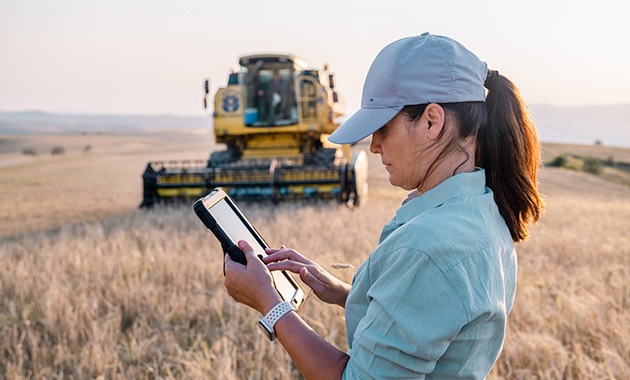 Farmer in field holding tablet