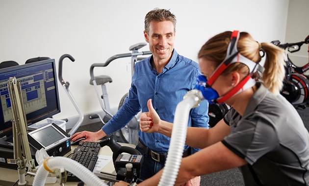 Person on exercise bike with measurement equipment attached