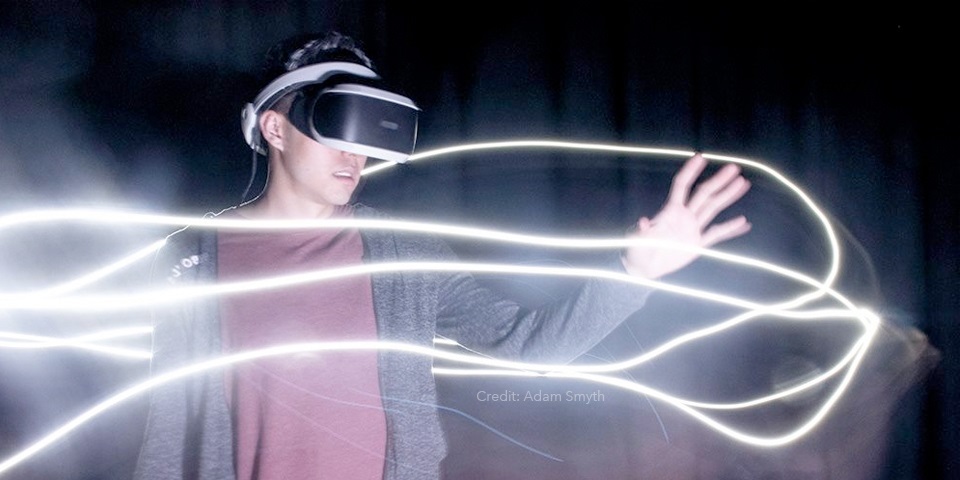 Young man using VR with light streaks